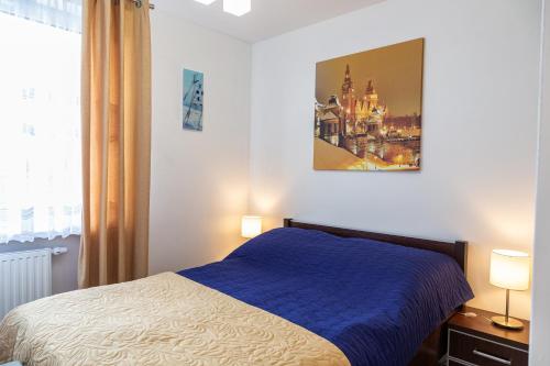 een slaapkamer met een bed en een schilderij aan de muur bij Apartament Yooka in Szczecin