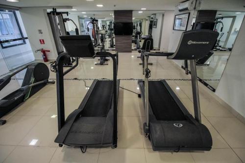 a gym with several treadmills in a room at Oscar Hotel Executive in Porto Velho