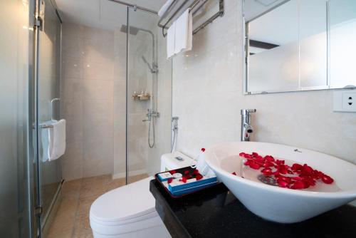 a bathroom with a white sink and a toilet at Le Beryl Hanoi Hotel in Hanoi