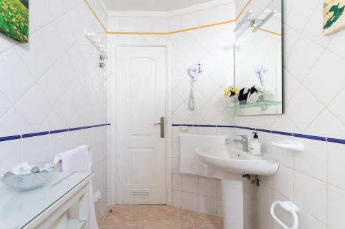 a white bathroom with a sink and a mirror at Vivienda Vacacional La Laguna Deluxe 6 in Las Lagunas