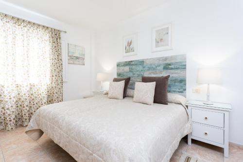 a white bedroom with a bed and a window at Vivienda Vacacional La Laguna Deluxe 6 in Las Lagunas