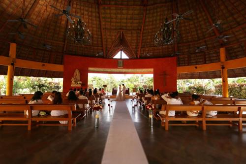 a group of people sitting on benches in a church at Barceló Maya Caribe - All Inclusive in Xpu Ha