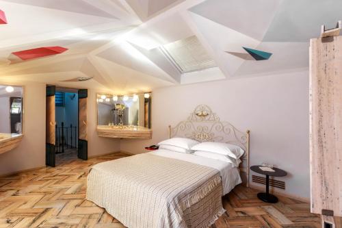 a bedroom with a white bed and a ceiling with geometric ceilings at Albergo Ristorante Madonnina in Cantello