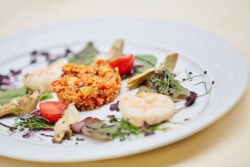 a white plate of food on a table at Landhotel Naafs-Häuschen in Lohmar