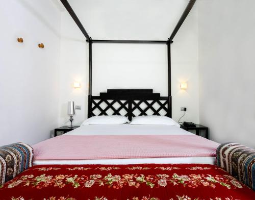 a bedroom with a large bed with a red blanket at Albergo Ristorante Madonnina in Cantello