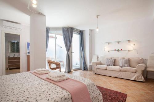 バレンシアにあるHabana Apartmentの白いベッドルーム(ベッド1台、ソファ付)