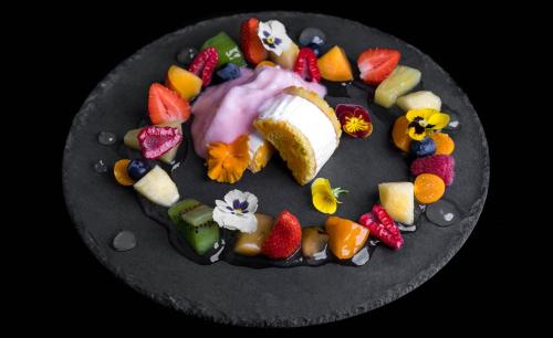 a plate of fruit and vegetables on a black plate at Albergo Ristorante Madonnina in Cantello