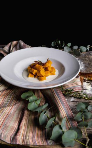 a white plate with a pile of food on a table at Albergo Ristorante Madonnina in Cantello