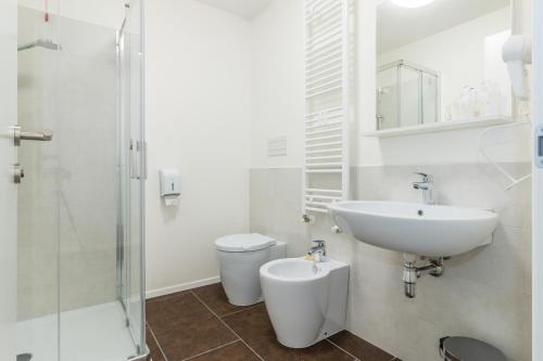 a white bathroom with a sink and a toilet at Hotel Cascina Fossata & Residence in Turin