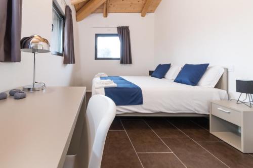 a bedroom with a bed with blue and white sheets at Hotel Cascina Fossata & Residence in Turin