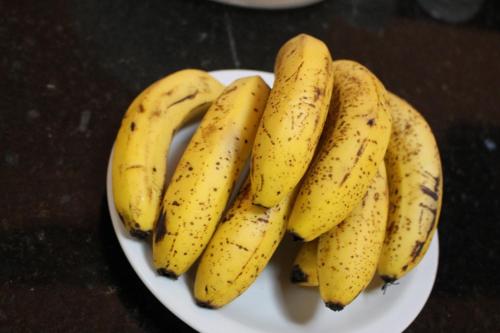 a bunch of bananas on a plate on a table at Pousada Canto Verde in Boicucanga