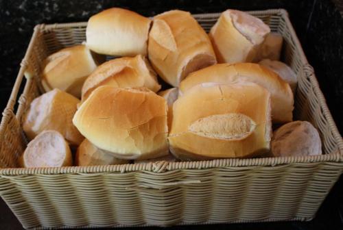 a basket full of buns sitting on a table at Pousada Canto Verde in Boicucanga