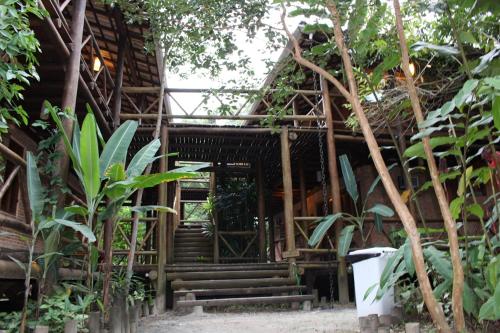 a wooden building with stairs in a garden at Pousada Canto Verde in Boicucanga