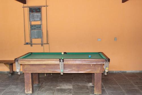 a pool table in the corner of a room at Pousada Canto Verde in Boicucanga