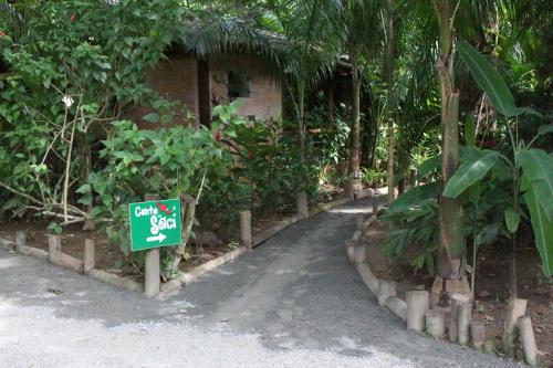 a street sign in front of a building with trees at Pousada Canto Verde in Boicucanga
