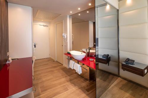 a bathroom with a red sink and a mirror at Hotel Ideal in Limone sul Garda
