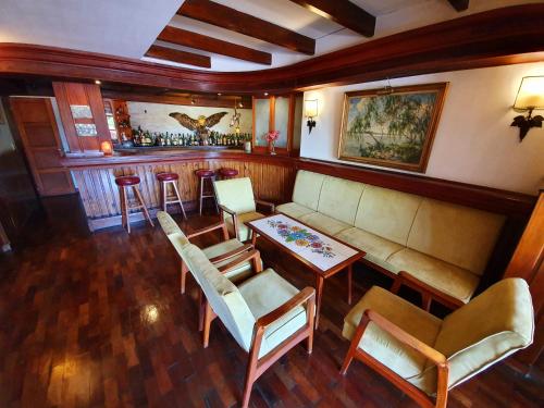 a living room with a couch and a bar at Hotel La Cumbrecita in La Cumbrecita