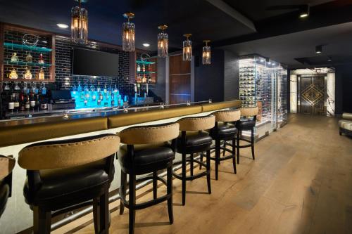 a bar with stools in a room with blue glasses at The Kindler Hotel in Lincoln