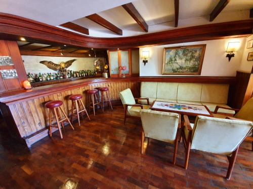 a restaurant with a bar with tables and chairs at Hotel La Cumbrecita in La Cumbrecita