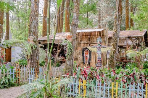 a garden with a wooden house in the woods at RedDoorz @ Apache Camp in Junggo