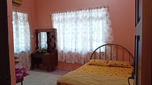 a bedroom with a bed and a mirror at Homestay Zahra Sri Bayu in Kampong Dalam Ru