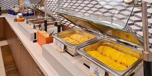 a buffet line with food in trays in a kitchen at Holiday Inn Express & Suites - Marion by IHG in Marion