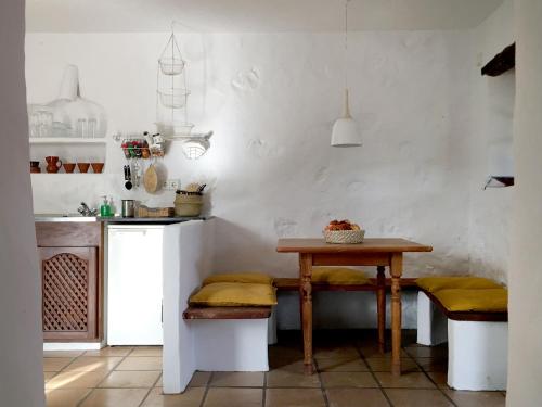 a kitchen with a table with yellow cushions and a table in a room at Casa Panama,in der Finca Mimosa in Teguise