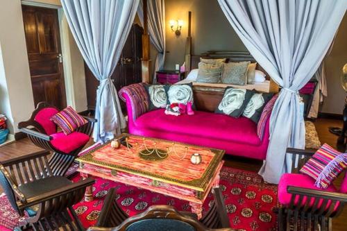 a living room with a pink couch and chairs at Casa Cara Resort in Parys