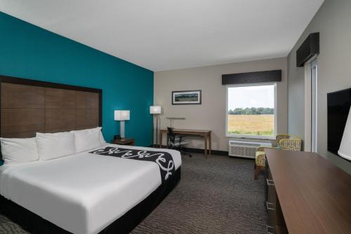 a hotel room with a bed and a television at La Quinta by Wyndham West Memphis in West Memphis