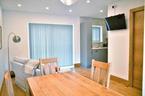 a dining room with a table and a couch at Red Watch Apartment in Oban