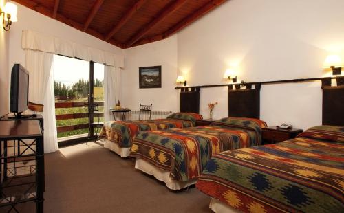 a group of four beds in a room at Sierra Nevada in El Calafate