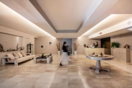 a person walking through a living room with a table at Grande Baia Resort & Spa in San Teodoro
