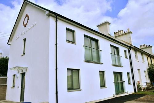 a white building with a clock on the side of it at Red Watch Apartment in Oban