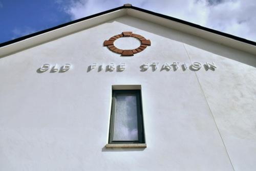 a white building with a clock on top of it at Red Watch Apartment in Oban
