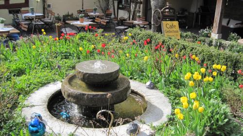 a bird standing next to a fountain in a garden at Hotel Gerberhaus in Rothenburg ob der Tauber