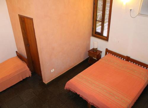 a bedroom with two beds and a window at Pousada Canto Verde in Boicucanga