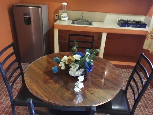 a wooden table with a vase of flowers on it at Hotel Las Salinas in Zihuatanejo
