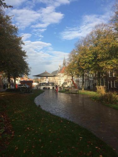 a river in the middle of a city with buildings at Slapen bij Van-V in Zierikzee