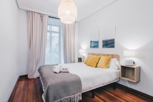 um quarto com uma cama e uma grande janela em Udaberri Apartment by People Rentals em San Sebastián