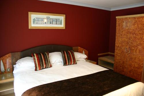 a bedroom with a bed with red walls at Beamish Park Hotel in Beamish