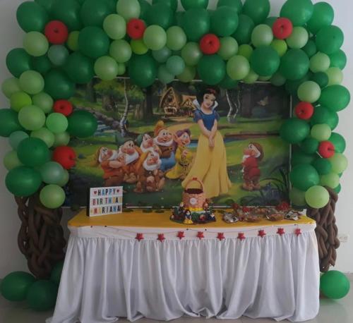 a disney princess party with a table with green balloons at Hotel Catama Inn in Fusagasuga