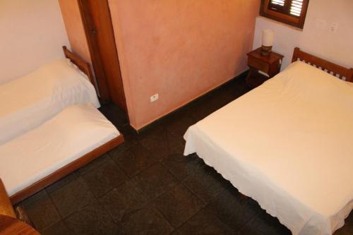a room with two beds and a window at Pousada Canto Verde in Boicucanga