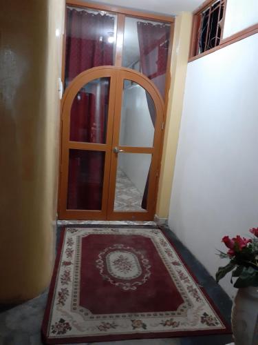 a hallway with a wooden door and a rug at Nasca Trails B&B in Nazca
