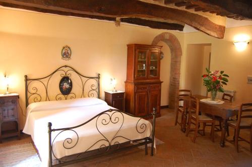 Un dormitorio con una cama y una mesa y sillas. en Agriturismo Casagrande, en Montepulciano