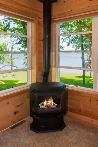a fireplace in a room with two windows at Leech Lake Resort Bed & Breakfast in Walker