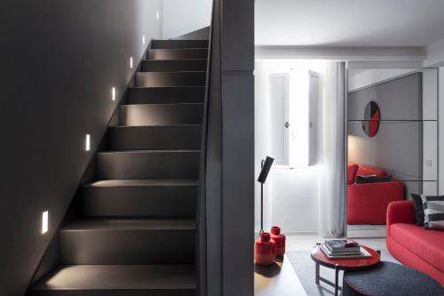 a staircase in a living room with a red couch at Hotel Plaza e de Russie - Relais & Châteaux in Viareggio