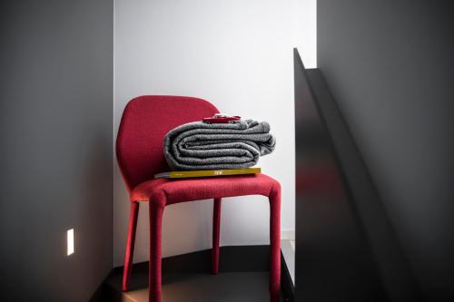 a red chair with a blanket on top of it at Hotel Plaza e de Russie - Relais & Châteaux in Viareggio
