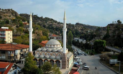 una moschea con due alte cupole bianche in una città di Lion City Hotel Ankara a Ankara