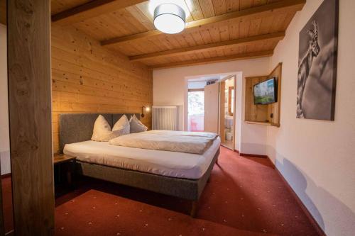 ein Schlafzimmer mit einem Bett in einem Holzzimmer in der Unterkunft Haus Steinbock in Neustift im Stubaital