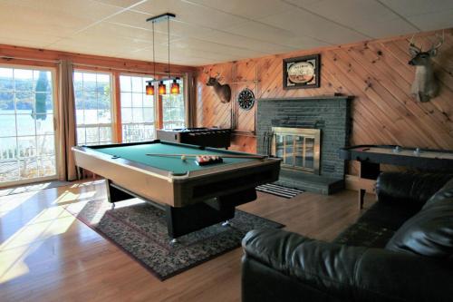 a living room with a pool table and a fireplace at Marina Vista in Penn Yan